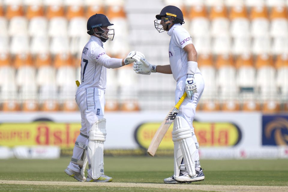 England’s Ben Duckett, left, and Joe Root bump their fists to celebrate (Anjum Naveed/AP)