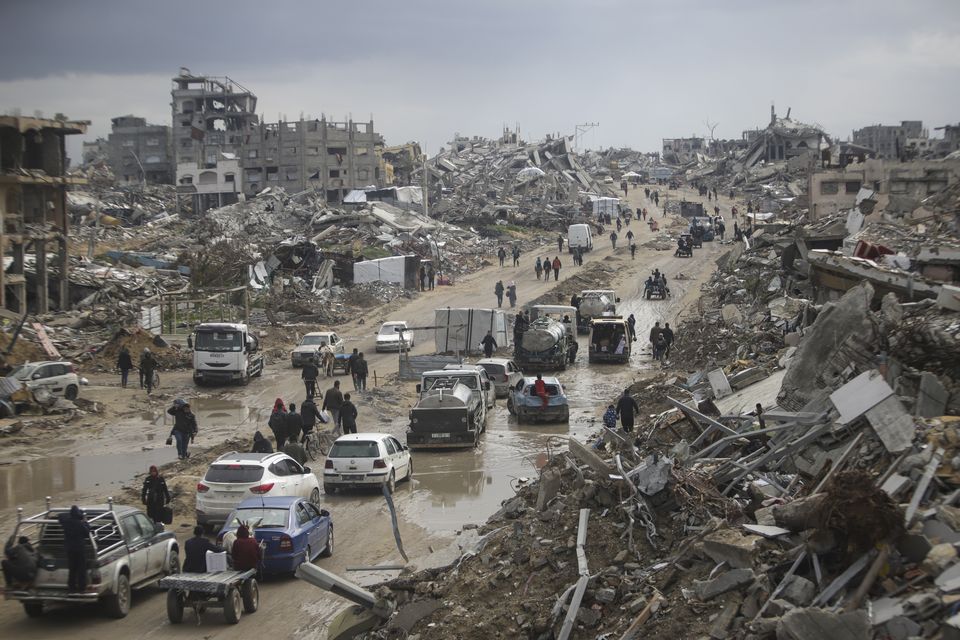 Cars move along a road amid destruction caused by the Israeli military’s offensive against Hamas (Jehad Alshrafi/AP