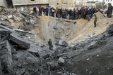 thumbnail: Palestinians gather in the crater of an Israeli missile strike on a building used by the Islamic group Hamas in Gaza City, Sunday, Dec. 28, 2008.  More than 270 Palestinians, have been killed and more than 600 people wounded since Israel's campaign to quash rocket barrages from Gaza began midday Saturday. (AP Photo/Khalil Hamra)