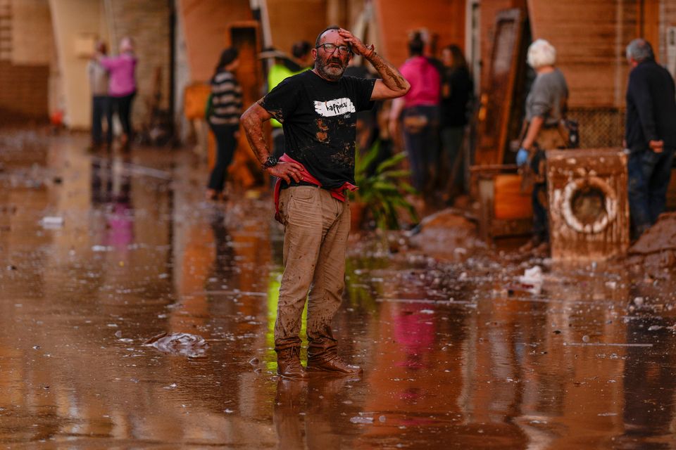 A man reacts in front of houses affected by floods in Utiel, Spain (Manu Fernandez/AP)