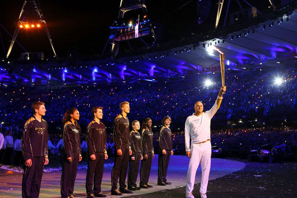 Steve Redgrave, right, holds up the Olympic flame after entering the stadium during the Opening Ceremony at the 2012 Summer Olympics, Saturday, July 28, 2012, in London. (AP Photo/Cameron Spencer, Pool)
