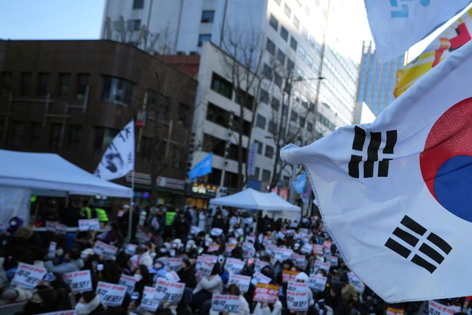 Participants hold signs during a rally calling on the Constitutional Court to dismiss President Yoon Suk Yeol in Seoul on Sunday. The signs read “Immediately arrest.” (Lee Jin-man/AP)